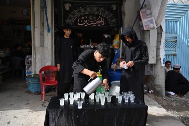 Afghan Shiite Muslims distribute sherbet on the tenth day of Ashura, during the Islamic holy month of Muharram in Kandahar on June 26, 2026. (Photo by Sanaullah SEIAM / AFP)