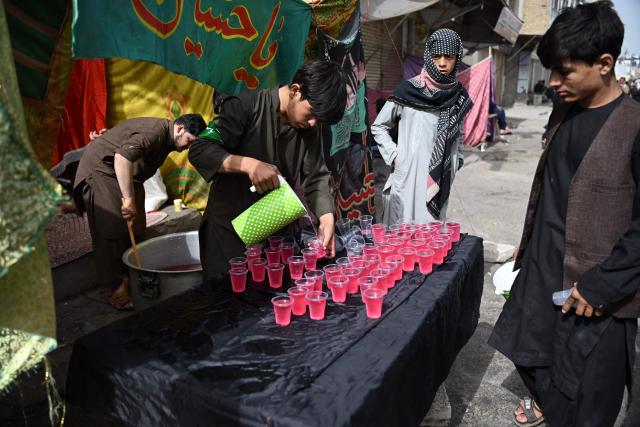 Afghan Shiite Muslims distribute sherbet on the tenth day of Ashura, during the Islamic holy month of Muharram in Kandahar on June 26, 2026. (Photo by Sanaullah SEIAM / AFP)