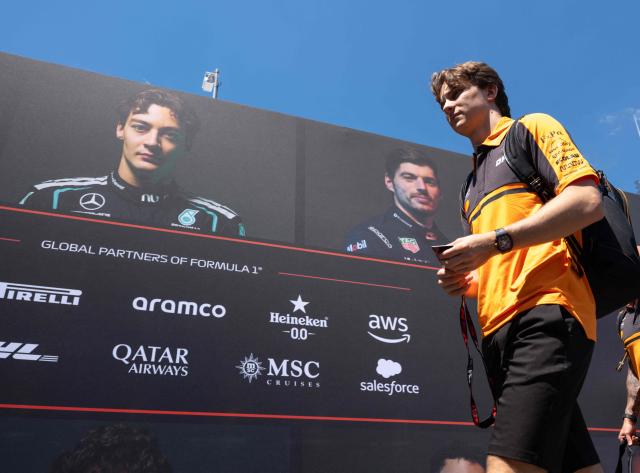 McLaren's Australian driver Oscar Piastri walks past a wall with portraits of current F1 drivers as he arrives to the paddock prior to the first practice session at the Red Bull Ring race track in Spielberg, Austria on June 26, 2026, ahead of the Formula One Austrian Grand Prix. (Photo by Joe KLAMAR / AFP)