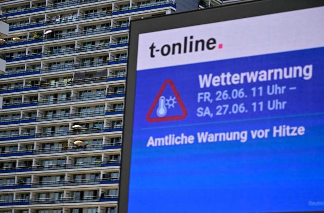 An information board displays a warning from extreme heat in Berlin, Germany, on June 26, 2026. A heatwave sweeping Europe was starting to peak in Germany, with several open-air events cancelled and temperatures expected to top 40C through the weekend. Large parts of the country are already under "severe to extreme heat stress", the German Weather Service (DWD) said. (Photo by Tobias SCHWARZ / AFP)