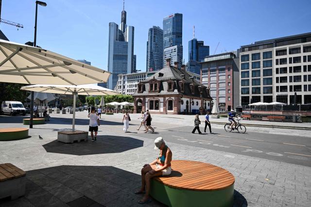 A woman rests in the sun shining outside the banking district in central Frankfurt am Main, western Germany, on June 26, 2026 with air temperature reaching 39 degrees Celsius. A heatwave sweeping Europe was starting to peak in Germany, with several open-air events cancelled and temperatures expected to top 40C through the weekend. Large parts of the country are already under "severe to extreme heat stress", the German Weather Service (DWD) said. (Photo by Kirill KUDRYAVTSEV / AFP)