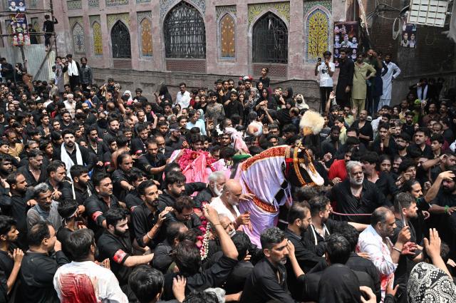 Shia Muslims take part in a religious procession marking Ashura on the tenth day of the Islamic holy month of Muharram in Lahore on June 26, 2026. (Photo by Arif ALI / AFP)