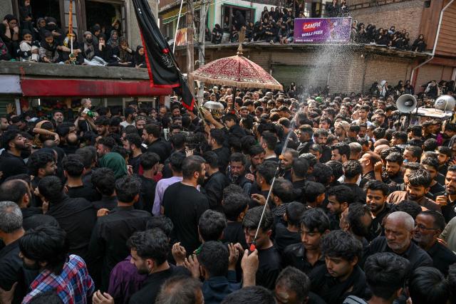 Kashmiri Shia Muslims gather around a horse symbolising the mount of Imam Hussein during a procession marking Ashura on the tenth day of the Islamic holy month of Muharram in Srinagar on June 26, 2026. (Photo by Tauseef MUSTAFA / AFP)