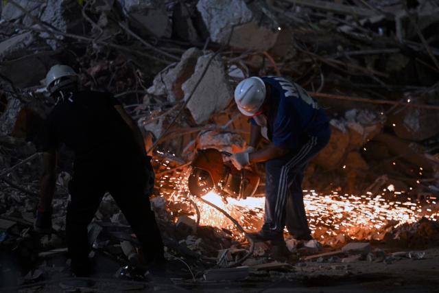 A rescuer cuts the steel bars of a collapsed building with an angle grinder in Caracas on June 25, 2026, following deadly earthquakes. Using heavy equipment or their bare hands, rescuers and volunteers searched for survivors of the twin earthquake in Venezuela, which has officially left 589 dead and, according to estimates, thousands missing. (Photo by Juan BARRETO / AFP)