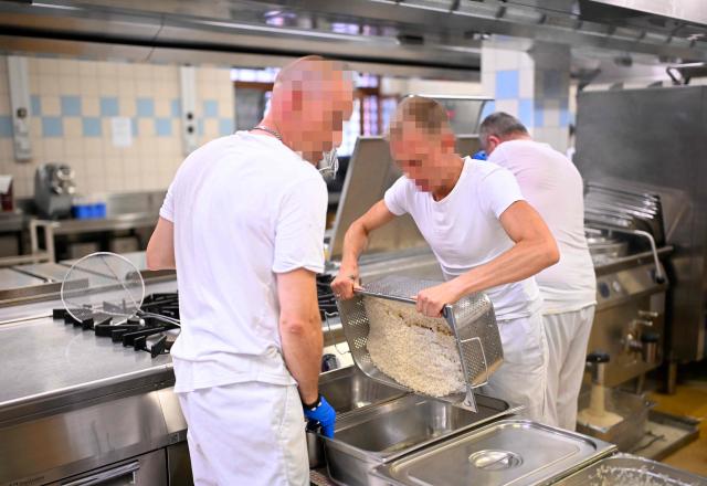 Prisoners prepare meals in a kitchen at Namur prison on June 23, 2026. Sharing a cell with two others around the clock has become a “living hell” during the heatwave, inmates at Namur prison in Belgium told AFP, highlighting chronic overcrowding in the country’s penitentiary system. (Photo by JOHN THYS / AFP)