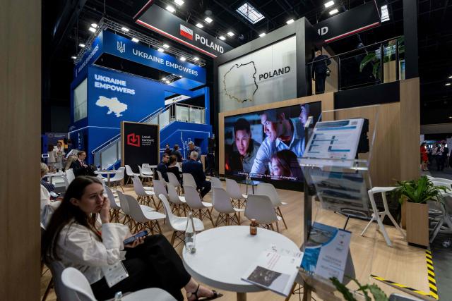 Visitors sit at business fair stands during the second day of the Ukraine Recovery Conference (URC 2026) hosted by the Poland's Prime Minister in Gdansk, Poland, on June 26, 2026. The Ukraine Recovery Conference (URC 2026), co-hosted by Poland and Ukraine, takes place in Gdansk on June 25–26, 2026, aiming to strengthen support for Ukraine’s reconstruction and boost investment, with a focus on energy, critical infrastructure, and logistics sectors. (Photo by Wojtek RADWANSKI / AFP)