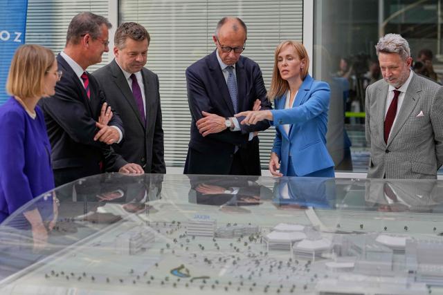 German Chancellor Friedrich Merz (C) is shown around pharmaceutical company Salutas Pharma by CEO Grit Mueller (2nd R) in Barleben, near Magdeburg, eastern Germany on June 26, 2026. (Photo by Matthias Schrader / POOL / AFP)