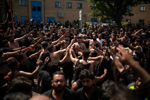 Shia Muslims take part in the annual Ashura procession in Bradford, northern England on June 26, 2026. Shiite Muslims, on the tenth day of the Islamic month of Muharram which marks the peak of Ashura, commemorate the martyrdom of Prophet Mohammad's grandson Imam Hussein, who was killed in the battle of Karbala in modern-day Iraq, in 680 AD. (Photo by Oli SCARFF / AFP)