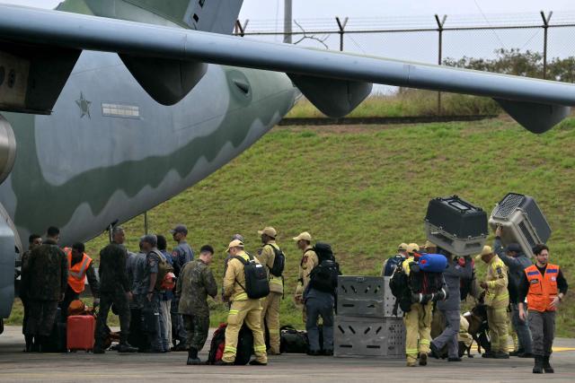 Brazilian firefighters, military personnel, and telecommunication technicians board a Brazilian Air Force plane for a humanitarian aid mission to Venezuela following deadly earthquakes, at Guarulhos air base in Guarulhos, Sao Paulo state, Brazil, on June 26, 2026. Using heavy equipment or their bare hands, rescuers and volunteers searched for survivors of the twin earthquake in Venezuela, which has officially left 589 dead and, according to estimates, thousands missing. (Photo by NELSON ALMEIDA / AFP)
