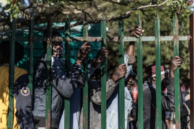 TOPSHOT - Malawian undocumented migrants, some of their hands marked to show that their documents have been vetted, gather as they line up hoping to board buses taking them back home at a temporary site along Mayor's Walk in Pietermaritzburg, on June 26, 2026. South Africans President Cyril Ramaphosa vowed on Thursday to crush any attempts to destabilise the nation during planned anti-immigrant marches next week, amid a wave of xenophobia.Citizen-led groups have set Tuesday 30 as a deadline for undocumented foreigners to leave and called for nationwide marches against illegal immigration, marking a crescendo in months of protests that have at times turned violent. (Photo by MARCO LONGARI / AFP)
