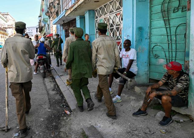 Cuban soldiers head to clear rubbish from street-corner dumps caused by the breakdown of waste collection amid the country’s ongoing crisis, in Old Havana, Cuba, on June 26, 2026. (Photo by YAMIL LAGE / AFP)