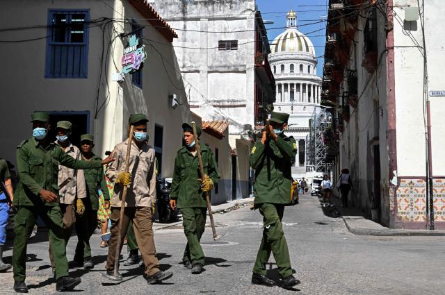 Cuban soldiers head to clear rubbish from street-corner dumps caused by the breakdown of waste collection amid the country’s ongoing crisis, in Old Havana, Cuba, on June 26, 2026. (Photo by YAMIL LAGE / AFP)