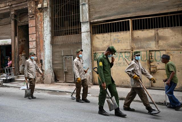 Cuban soldiers head to clear rubbish from street-corner dumps caused by the breakdown of waste collection amid the country’s ongoing crisis, in Old Havana, Cuba, on June 26, 2026. (Photo by YAMIL LAGE / AFP)