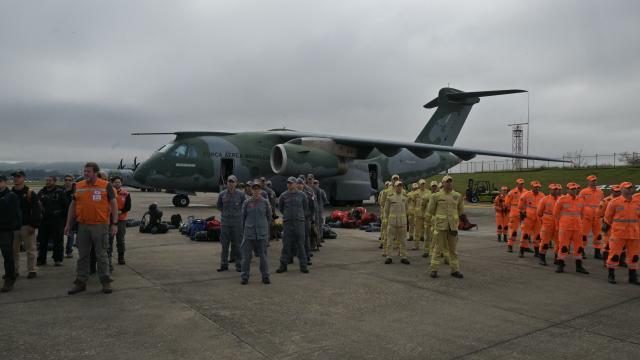 Brazilian firefighters, military personnel, and telecommunication technicians get ready to board a Brazilian Air Force plane for a humanitarian aid mission to Venezuela following deadly earthquakes, at Guarulhos air base in Guarulhos, Sao Paulo state, Brazil, on June 26, 2026. Using heavy equipment or their bare hands, rescuers and volunteers searched for survivors of the twin earthquake in Venezuela, which has officially left 589 dead and, according to estimates, thousands missing. (Photo by NELSON ALMEIDA / AFP)