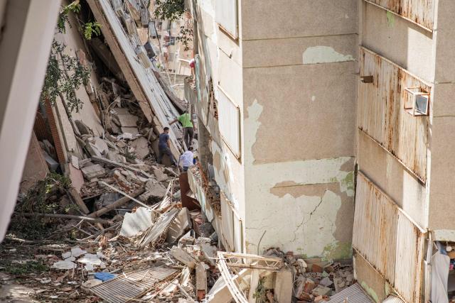 People search for survivors through the rubble following twin earthquakes in Caraballeda, La Guaira State, some 40 km northeast of Caracas, on June 25, 2026. The death toll from twin earthquakes in Venezuela more than doubled on June 26, 2026, to 589, interim president Delcy Rodriguez said, as rescuers boosted by international teams raced to find survivors beneath collapsed buildings. Over 50,000 people are missing after the earthquakes in Venezuela, a senior UN official told AFP. (Photo by Donaldo BARROS / AFP)
