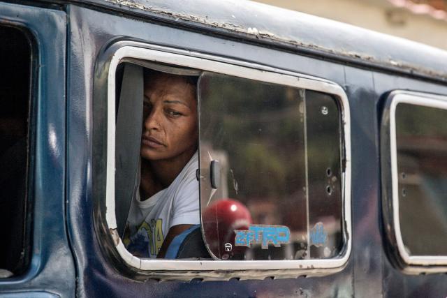 A woman with a vacant gaze sits inside a van following twin earthquakes in Caraballeda, La Guaira State, some 40 km northeast of Caracas, on June 25, 2026. The death toll from twin earthquakes in Venezuela more than doubled on June 26, 2026, to 589, interim president Delcy Rodriguez said, as rescuers boosted by international teams raced to find survivors beneath collapsed buildings. Over 50,000 people are missing after the earthquakes in Venezuela, a senior UN official told AFP. (Photo by Donaldo BARROS / AFP)