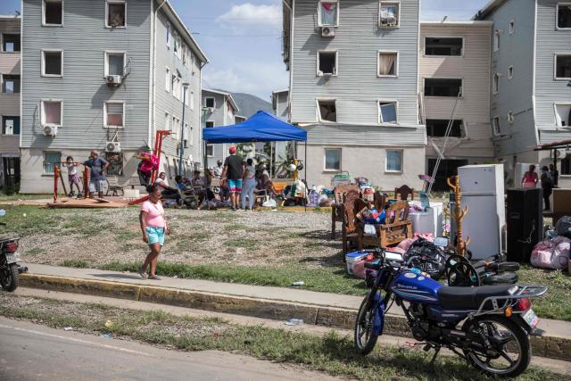 People remain outside damaged buildings following twin earthquakes in Caraballeda, La Guaira State, some 40 km northeast of Caracas, on June 25, 2026. The death toll from twin earthquakes in Venezuela more than doubled on June 26, 2026, to 589, interim president Delcy Rodriguez said, as rescuers boosted by international teams raced to find survivors beneath collapsed buildings. Over 50,000 people are missing after the earthquakes in Venezuela, a senior UN official told AFP. (Photo by Donaldo BARROS / AFP)