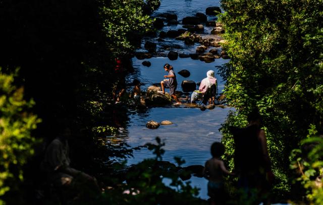 A family cools off in a cascade at Berlin's Viktoria Park on June 26, 2026, as temperatures went past 30 degrees Centigrade in the German capital. Germany saw temperatures break 40C at several locations in the country on June 26, 2026, according to preliminary weather service data, breaking the previous recorded high of 39.6C for the month of June. (Photo by John MACDOUGALL / AFP)