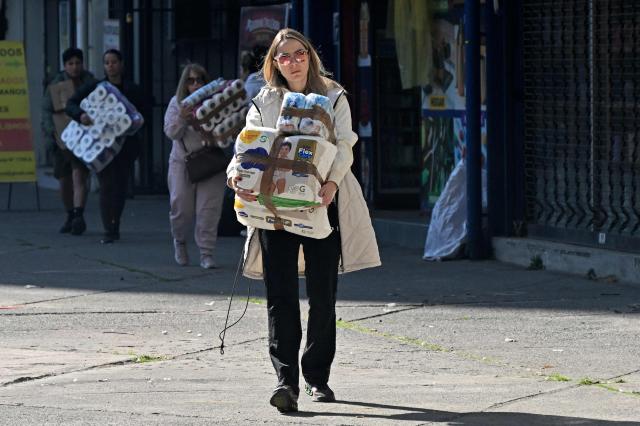 People bring hygiene products to a collection centre as Venezuelans living in Santiago gather supplies to send to their earthquake-stricken homeland, on June 26, 2026, in Santiago, Chile. So far, 589 deaths and more than 50,000 missing people have been reported. after twin earthquakes in Venezuela, as international rescue teams and sniffer dogs arrived to join a desperate search for survivors. (Photo by RODRIGO ARANGUA / AFP)