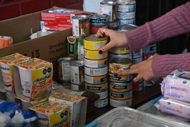 A woman arranges goods at a collection centre as Venezuelans living in Santiago gather supplies to send to their earthquake-stricken homeland, on June 26, 2026, in Santiago, Chile. So far, 589 deaths and more than 50,000 missing people have been reported. after twin earthquakes in Venezuela, as international rescue teams and sniffer dogs arrived to join a desperate search for survivors. (Photo by RODRIGO ARANGUA / AFP)