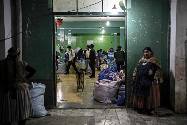 Vendors and workers handle large sacks of coca leaves inside the legal coca market in La Paz, on June 26, 2026 (Photo by MARTIN BERNETTI / AFP)