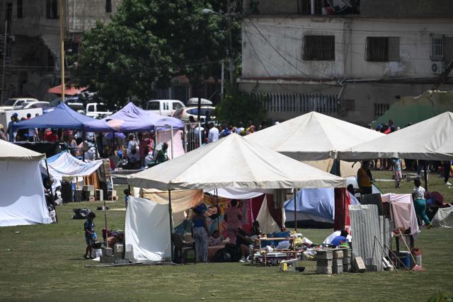 Residents take shelter at a sports field in Catia La Mar, La Guaira, Venezuela, on June 26, 2026, following earthquakes. The death toll from two powerful earthquakes that devastated Venezuela earlier this week rose to 920 on June 26, National Assembly President Jorge Rodriguez said. (Photo by Federico PARRA / AFP)