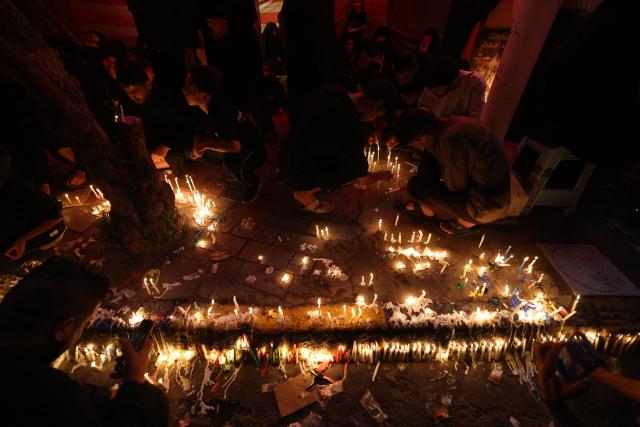 Shiite Muslims light candles near the shrine of Imam Hussein during the traditional Tuwairij Run, as part of Ashura, a 10-day period commemorating the seventh century killing of Prophet Mohammed's grandson Imam Hussein, in the Iraqi holy city of Karbala, on July 26, 2026. (Photo by AHMAD AL-RUBAYE / AFP)