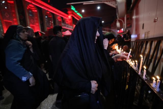 Shiite Muslims light candles near the shrine of Imam Hussein during the traditional Tuwairij Run, as part of Ashura, a 10-day period commemorating the seventh century killing of Prophet Mohammed's grandson Imam Hussein, in the Iraqi holy city of Karbala, on July 26, 2026. (Photo by AHMAD AL-RUBAYE / AFP)