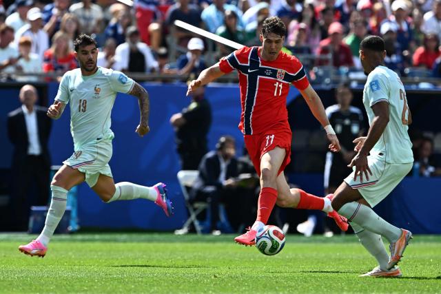 France's defender #19 Theo Hernandez, Norway's forward #11 Jorgen Strand Larsen and France's defender #26 Maxence Lacroix fight for the ball during the 2026 World Cup Group I football match between Norway and France at the Boston Stadium in Foxborough on June 26, 2026.  (Photo by Jewel SAMAD / AFP)