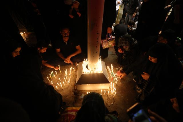 Shiite Muslims light candles near the shrine of Imam Hussein during the traditional Tuwairij Run, as part of Ashura, a 10-day period commemorating the seventh century killing of Prophet Mohammed's grandson Imam Hussein, in the Iraqi holy city of Karbala, on July 26, 2026. (Photo by AHMAD AL-RUBAYE / AFP)