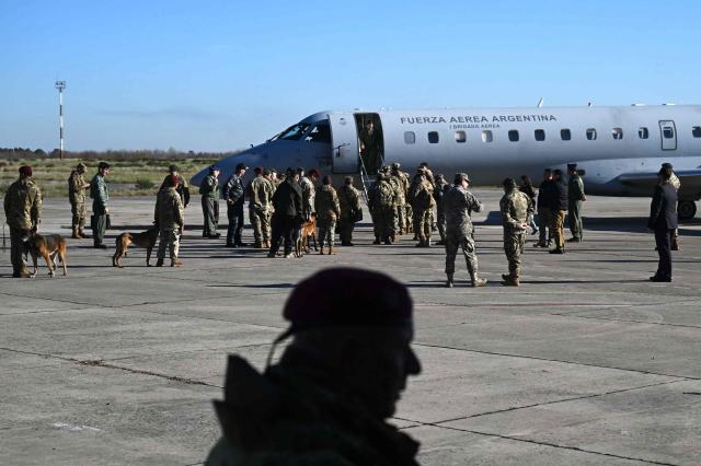 Argentine Navy rescue personnel with sniffer dogs board an Argentine Air Force Embraer ERJ 140 aircraft at El Palomar Air Base, on the outskirts of Buenos Aires, Argentina, on June 26, 2026, as they depart for Venezuela to assist rescue operations following deadly earthquakes. The death toll from two powerful earthquakes that devastated Venezuela earlier this week rose to 920 on June 26, National Assembly President Jorge Rodriguez said. (Photo by Luis ROBAYO / AFP)