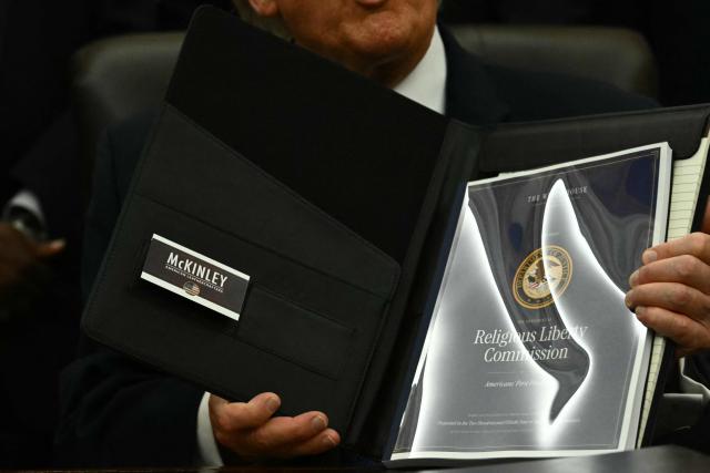 US President Donald Trump presents findings of his Religious Liberty Commission in the Oval Office of the White House, in Washington, DC on June 26, 2026. (Photo by Kent NISHIMURA / AFP)