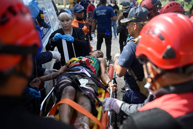 EDITORS NOTE: Graphic content / Venezuelan Civil Protection members and firefighters tend to 21-year-old Patrick Vargas after rescuing him from the rubble of a collapsed building in Catia La Mar, La Guaira, Venezuela, on June 26, 2026, following earthquakes. The death toll from two powerful earthquakes that devastated Venezuela earlier this week rose to 920 on June 26, National Assembly President Jorge Rodriguez said. (Photo by Federico PARRA / AFP)