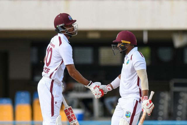 Roston Chase (L) congratulates Amir Jangoo (R) of West Indies for his half century during the 2nd day of the 1st Test between Sri Lanka and West Indies at Vivian Richards Cricket Stadium in North Sound, Antigua and Barbuda, on June 26, 2026. (Photo by Randy Brooks / AFP)