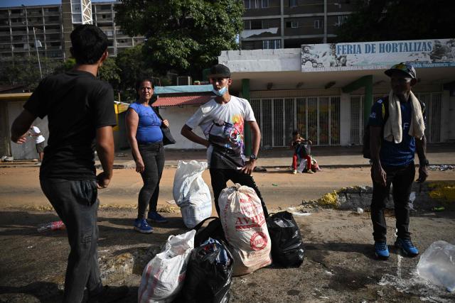 EDITORS NOTE: Graphic content / People stand beside bags of belongings on a street in Catia La Mar, La Guaira, Venezuela, on June 26, 2026, after twin earthquakes struck the country. The death toll from two powerful earthquakes that devastated Venezuela earlier this week rose to 920 on June 26, National Assembly President Jorge Rodriguez said. (Photo by Federico PARRA / AFP)