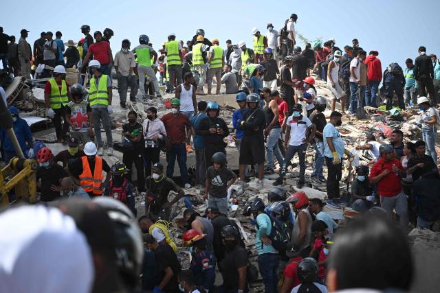 EDITORS NOTE: Graphic content / Rescuers, volunteers and residents gather on the rubble of collapsed buildings during search and recovery operations in Catia La Mar, La Guaira, Venezuela, on June 26, 2026, following deadly earthquakes. The death toll from two powerful earthquakes that devastated Venezuela earlier this week rose to 920 on June 26, National Assembly President Jorge Rodriguez said. (Photo by Federico PARRA / AFP)