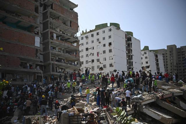 EDITORS NOTE: Graphic content / Rescuers, volunteers and residents gather on the rubble of collapsed buildings during search and recovery operations in Catia La Mar, La Guaira, Venezuela, on June 26, 2026, following deadly earthquakes. The death toll from two powerful earthquakes that devastated Venezuela earlier this week rose to 920 on June 26, National Assembly President Jorge Rodriguez said. (Photo by Federico PARRA / AFP)