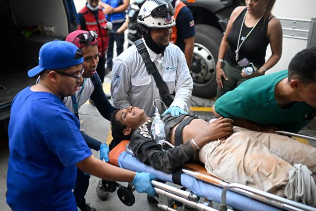 A young person is rushed into the Pariata Hospital in La Guaira state, Venezuela, on June 26, 2026, after being rescued from the rubble following deadly earthquakes. The death toll from two powerful earthquakes that devastated Venezuela earlier this week rose to 920 on June 26, National Assembly President Jorge Rodriguez said. (Photo by Federico PARRA / AFP)