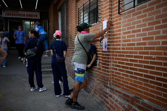 A relative checks a list of injured patients posted on a wall outside the emergency ward of Pariata Hospital in La Guaira state, Venezuela, on June 26, 2026, following deadly earthquakes. The death toll from two powerful earthquakes that devastated Venezuela earlier this week rose to 920 on June 26, National Assembly President Jorge Rodriguez said. (Photo by Federico PARRA / AFP)