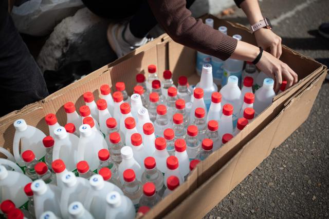 A volunteer organizes bottles of alcohol as humanitarian aid to be sent to Venezuela following deadly earthquakes, in Bogota on June 26, 2026. The death toll from two powerful earthquakes that devastated Venezuela earlier this week rose to 920 on June 26, National Assembly President Jorge Rodriguez said. (Photo by ESTEBAN VEGA LA-ROTTA / AFP)