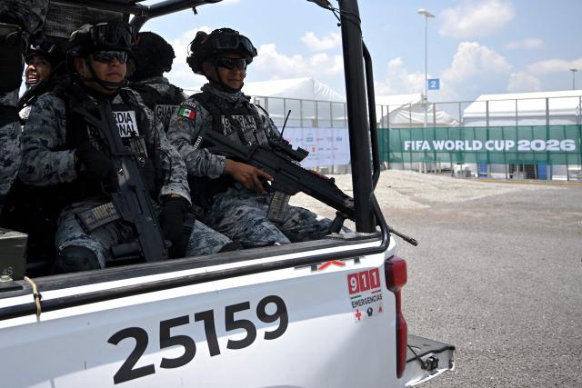 National guard officers stand guard on a pickup truck outside the Guadalajara Stadium before the 2026 World Cup Group H football match between Uruguay and Spain in Zapopan on June 26, 2026.  (Photo by CARL DE SOUZA / AFP)