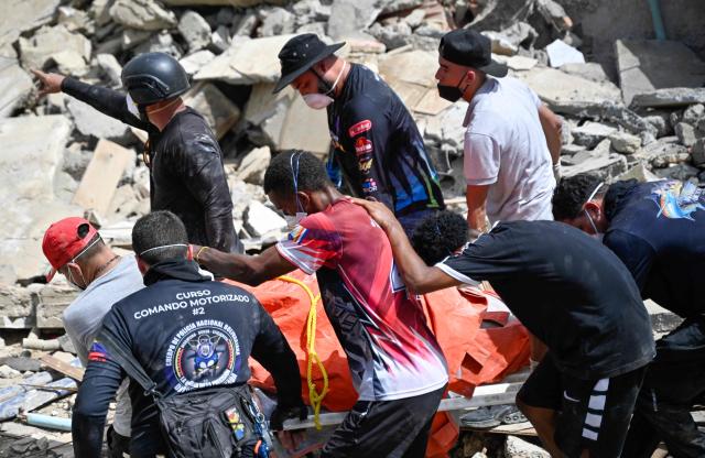 Venezuelan Civil Protection members and volunteers recover a body at the site of collapsed buildings following earthquakes in Caraballeda, La Guaira state, Venezuela, on June 26, 2026. The death toll from two powerful earthquakes that devastated Venezuela earlier this week rose to 920 on June 26, National Assembly President Jorge Rodriguez said. (Photo by Maryorin Mendez / AFP)