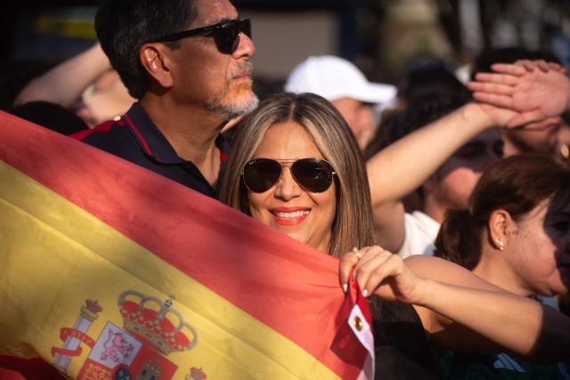 A Spain fan holds a Spanish flag at the FIFA Fan Festival, held at Plaza de la Liberacion and Plaza de Armas, in Guadalajara, Mexico, as supporters watch the 2026 World Cup Group H football match between Uruguay and Spain on June 26, 2026. (Photo by RUTH ROSAS / AFP)