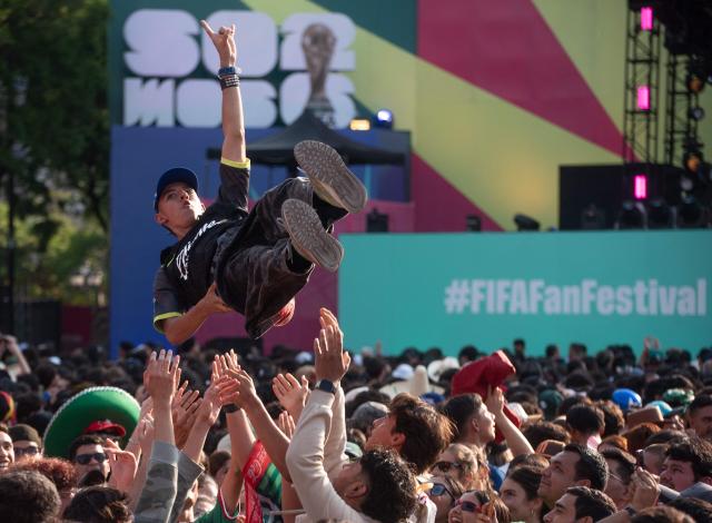 Fans lift a person into the air in front of a stage at the FIFA Fan Festival, held at Plaza de la Liberacion and Plaza de Armas, in Guadalajara, Mexico, as supporters watch the 2026 World Cup Group H football match between Uruguay and Spain on June 26, 2026. (Photo by RUTH ROSAS / AFP)