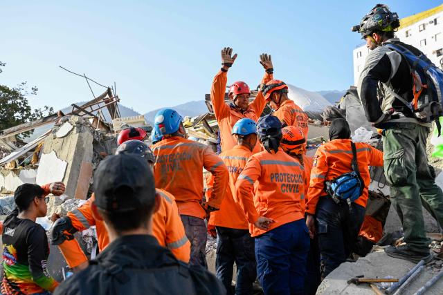 Venezuelan Civil Protection members work at the site of a collapsed building following earthquakes in Caraballeda, La Guaira state, Venezuela, on June 26, 2026. The death toll from two powerful earthquakes that devastated Venezuela earlier this week rose to 920 on June 26, National Assembly President Jorge Rodriguez said. (Photo by Maryorin Mendez / AFP)