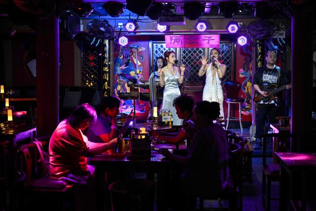 Singers performs in a club in Chengdu, in China's southwestern Sichuan province on June 26, 2026. (Photo by HECTOR RETAMAL / AFP)