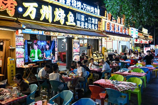 People enjoy some meals in restaurants in Chengdu, in China's southwestern Sichuan province on June 26, 2026. (Photo by HECTOR RETAMAL / AFP)