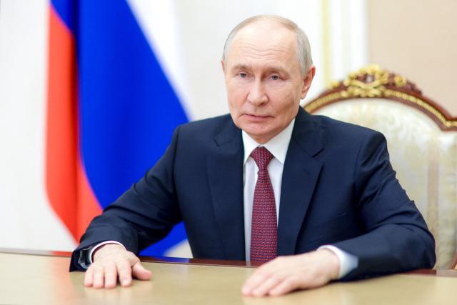 In this pool photograph distributed by the Russian state agency Sputnik, Russian President Vladimir Putin congratulates Russian graduates on finishing school in Moscow on June 26, 2026. (Photo by Gavriil Grigorov / POOL / AFP)