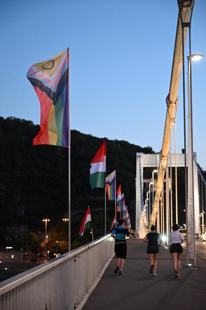 The 'Progress Pride' rainbow flags is seen on the Erzsebet Bridge in Budapest, Hungary, on June 26, 2026, a day before Budapest Pride. A right-wing sympathizer removed several flags and threw them into the Danube, after which activists from far-right parliamentary party, the 'Our Homeland Movement' placed Hungarian national flags on the bridge few days ago. (Photo by Attila KISBENEDEK / AFP)