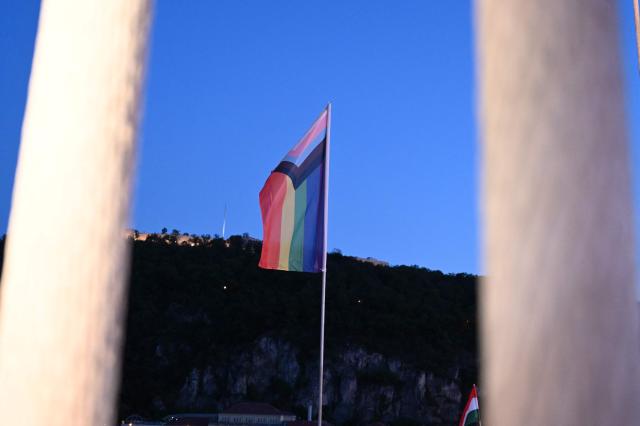 The 'Progress Pride' rainbow flags is seen on the Erzsebet Bridge in Budapest, Hungary, on June 26, 2026, a day before Budapest Pride. A right-wing sympathizer removed several flags and threw them into the Danube, after which activists from far-right parliamentary party, the 'Our Homeland Movement' placed Hungarian national flags on the bridge few days ago. (Photo by Attila KISBENEDEK / AFP)